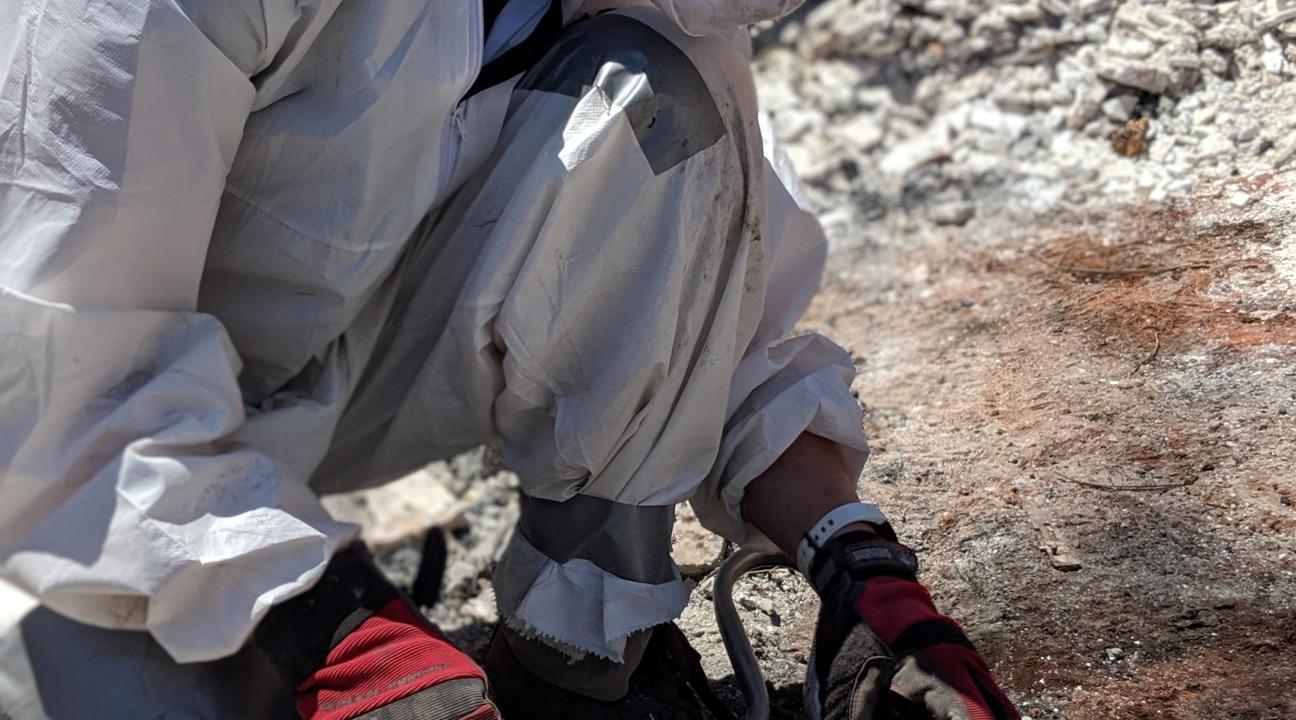 Risa DeGeorgey excavates cremains from within the wreckage of a fire destroyed home.
