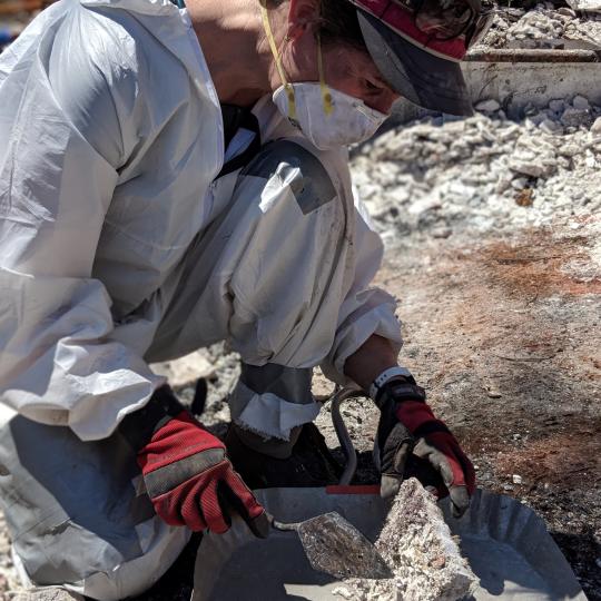 Risa DeGeorgey excavates cremains from within the wreckage of a fire destroyed home.